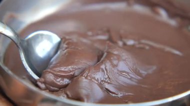 Bir aşçı çikolatayı karıştırır ve mutfakta tatlı bir yemek hazırlar..