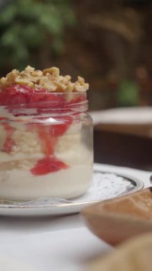 Şef katmanlı yoğurt, çilek ve cam kavanozda fındık..