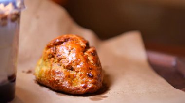 Bir insan kırsal bir masada otururken hamur işi yiyor..