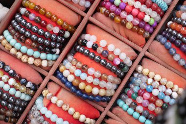 Farklı renk ve malzemelere sahip birçok bilezik bir pazar standında bulunmaktadır..