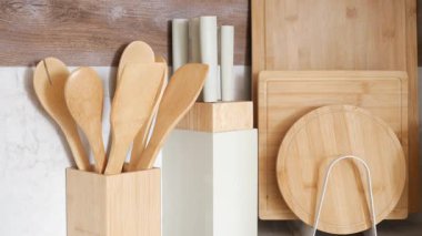 Çeşitli ahşap mutfak aletleri ve kesme tahtaları düzgünce düzenlenmiştir..