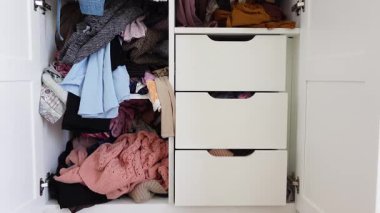 Giysileri sınıflandırmak ve pratik fikirlerle karışık bir dolap düzenlemek..