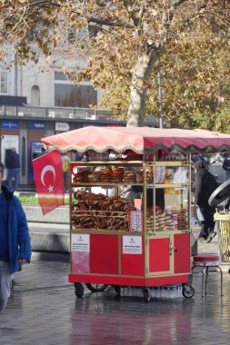 Yoğun bir Türk meydanında ekmek satan bir adam at arabasının yanından geçiyor.