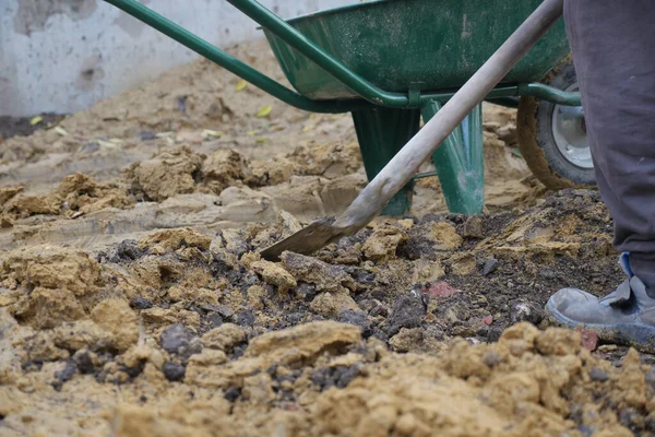 Erkekler şehirde inşaat için toprak ve kayaları temizlemek için aletlerle çalışırlar..
