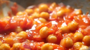 Chickpeas are cooked with tomato and onion on the stovetop now.