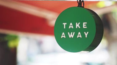 Bir gıda dükkanının önünde yeşil bir tabela asılı. Kelimeleri alıp götürüyor..