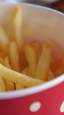 Kırmızı bardakta malzemesiz servis edilen sıcak, taze patates kızartması..