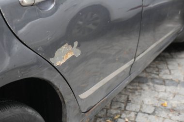 Bir araba, sokağın yanındaki yan panelde boya izi gösteriyor..