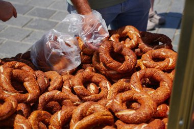 Gündüz pazarında taze Türk simit almak için ellerini uzat.,