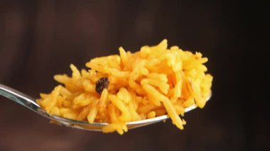 Bir aşçı mutfak ortamında baharatlı pirinç yemeği hazırlar..