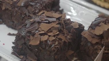 Çikolata parçacıkları ile beyaz bir tabağa iki çikolatalı tatlı konur..