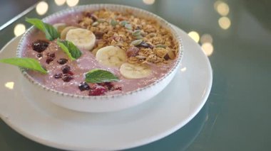 İnsan masada oturur ve soslu meyve kokteylinin tadını çıkarır..