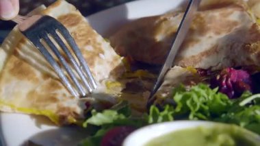 Quesadilla kesmek ve masada salatanın tadını çıkarmak..