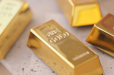 Altın külçeleri bir yüzeye yerleştirilir, parlaklıklarını ve tasarımlarını sergilerler..