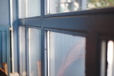 İnsanlar gün ışığında büyük bir pencerenin yanında toplanıyor..