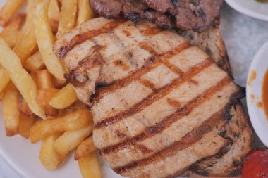 Tabakta kızarmış tavuk ve kızarmış patates var..