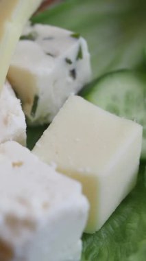 Küçük peynir küpleri taze salatalık dilimleriyle düzenlenir..