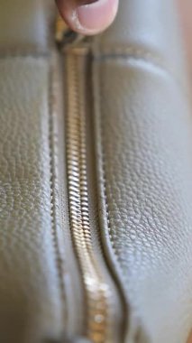 Yakından bakınca gün ışığında deri bir eşyanın fermuarını görüyoruz..