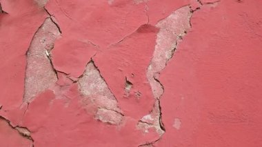 Kırık bir kırmızı duvara yakından bakınca aşınma izleri görülüyor..