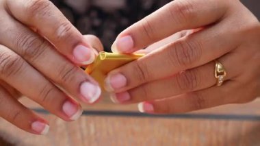 Çikolatalı şekerlemeleri açan ellerin yakın çekimi.