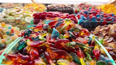 Bir pazarda parlak renklerde pek çok tür şeker gösterilir.