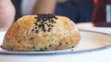 Siyah susam tohumlarıyla kaplı sıcak bir hamur işine yakından bakın..