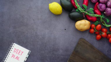 Taze sebzeler ve meyveler bir diyet planıyla bir yüzeye yerleştirilir..