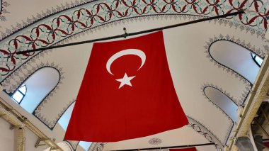 Bir pazar binası içinde büyük bir Türk bayrağı sergileniyor.