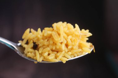 Bir kaşık sarı pirinci yemek sırasında yemeye hazır tutar..