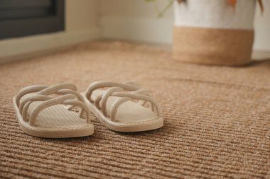 Bir çift basit sandalet, parlak bir odada yerde yatıyor..