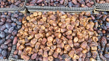 Tedarikçiler yoğun bir pazarda çeşitli tarih türlerini sepetlerde gösterirler.