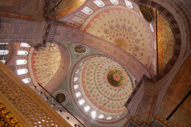 Ziyaretçiler gün ortasında caminin ayrıntılı tavanına bakıyorlar.