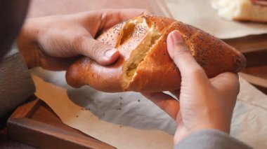 Bir kafede taze ekmek bulunduran kişi sıcak bir içkinin tadını çıkarır..