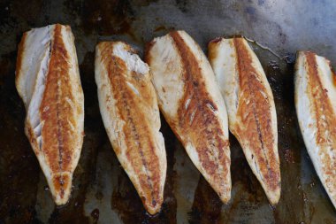 Beş balık fileto mutfakta ızgarada pişiyor..