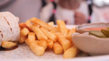 İnsanlar yerel bir yerde toplanmış patates kızartmasının ve sosun tadını çıkarıyorlar..
