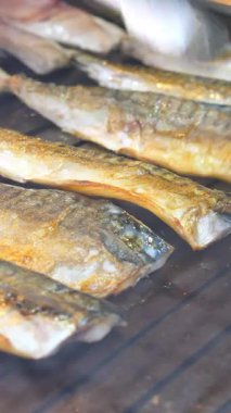 Balıklar alevler içinde kızartılıyor, duman yükseliyor..