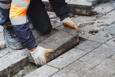Bir işçi gün içinde inşaat alanında yere tuğla yerleştirir..