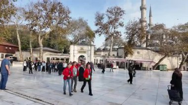 İstanbul 'da gündüz turu sırasında insanlar caminin önünde yürüyorlar.
