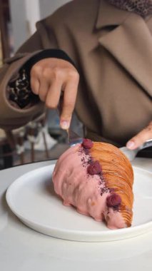 Bir kişi yerel bir kafede tatlıyı çatal bıçakla keser..