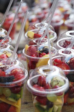 Renkli meyve tabakları satılık ve keyifli bir pazarda bir masa oluşturur..