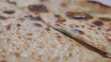 Bir insan temel malzemelerle fırında yassı ekmek pişirir..