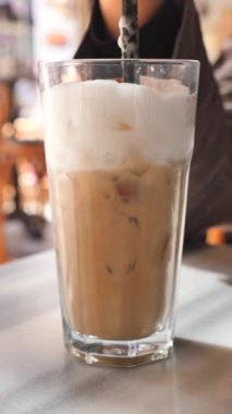 İnsanlar güneşli bir öğleden sonra buzlu kahve içmek için kafede toplanırlar..