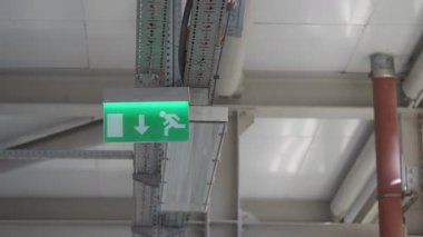 Yeşil bir çıkış işareti içerideki acil çıkışa giden yolu gösteriyor..