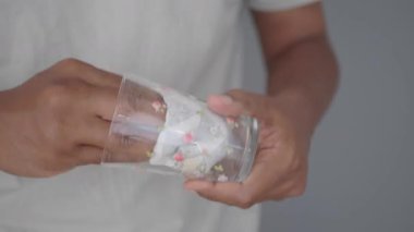 Bir insan bardağı dikkatle tutarken bir bez kullanır..