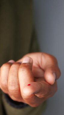 Parmak diyabetik testler için küçük bir damla kan gösteriyor. ,