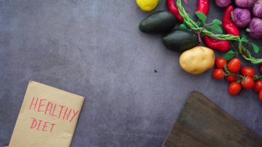 Taze sebzelerin yanında diyet planı olan bir not defteri var..