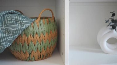 Bir sepet ve bir vazo odadaki bir rafa stil katar..