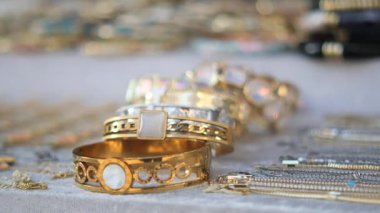 Ziyaretçilerin bakması için pazardaki bir masada altın bilezikler gösteriliyor.