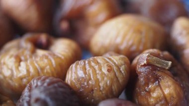 Kurutulmuş incirler mavi bir tabakta düzgünce dizilir ve dokularını gösterir..