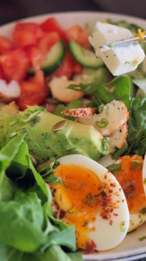 Bir insan yumurta, yeşillik, salatalık ve domatesli salatadan hoşlanır..